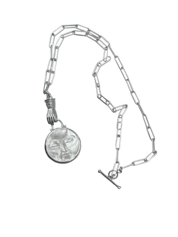 Holding the moon pendant.